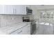 Modern kitchen with white shaker cabinets, granite counters, and stainless steel appliances at 324 Monet Dr, Nokomis, FL 34275