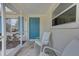 Bright screened porch with teal door and comfy chairs at 324 Monet Dr, Nokomis, FL 34275
