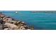 Rocks and ocean with a boat and people fishing at 335 Pembroke S Ln # 229, Venice, FL 34293