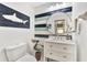 Stylish powder room with coastal decor and a white vanity at 335 Pembroke S Ln # 229, Venice, FL 34293