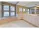 Bathroom boasts double vanity, large mirror, and tiled floor at 339 Meadow Beauty Ct, Venice, FL 34293