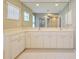 Bathroom with double vanity and large mirror reflecting the room at 339 Meadow Beauty Ct, Venice, FL 34293