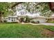 Single-story house with tile roof, manicured lawn, and mature trees at 339 Meadow Beauty Ct, Venice, FL 34293