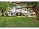 House with a tile roof, large trees, and a well-maintained lawn at 339 Meadow Beauty Ct, Venice, FL 34293