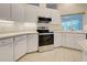 Stainless steel appliances and white cabinetry in this well-lit kitchen at 339 Meadow Beauty Ct, Venice, FL 34293