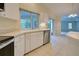 Kitchen features white cabinets, stainless steel dishwasher, and a window overlooking the backyard at 339 Meadow Beauty Ct, Venice, FL 34293