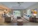 Living room with sliding glass doors opening to backyard, neutral decor, and hardwood floors at 339 Meadow Beauty Ct, Venice, FL 34293