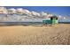 Lifeguard stand on sandy beach with ocean and cloudy sky in background at 341 Pembroke Ln # 227, Venice, FL 34293