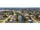 Aerial view showcasing the neighborhood and distant ocean, surrounded by lush greenery and a pond at 3560 Middletown St, Port Charlotte, FL 33952