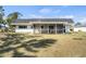 Home's backyard features a spacious lawn and a comfortable screened-in porch at 3560 Middletown St, Port Charlotte, FL 33952