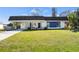 Charming single Gathering home with a well-manicured lawn and a combination stone and blue accent wall at 3560 Middletown St, Port Charlotte, FL 33952