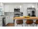 Modern kitchen featuring white cabinets, stainless steel appliances, and a butcher block island with bar stool seating at 3560 Middletown St, Port Charlotte, FL 33952
