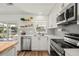 Bright kitchen features white cabinets, stainless steel appliances, and wood-look flooring at 3560 Middletown St, Port Charlotte, FL 33952