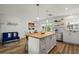 Bright, modern kitchen with island, seating, stainless appliances and wood-look flooring at 3560 Middletown St, Port Charlotte, FL 33952