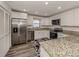 Modern kitchen with white cabinets, granite countertops, and stainless steel appliances at 4060 Barbary Ln, North Port, FL 34287