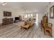 Bright living room with hardwood floors, comfy seating, and large windows at 4060 Barbary Ln, North Port, FL 34287