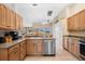 Modern kitchen with stainless steel appliances and wood cabinets at 4264 Wordsworth Way, Venice, FL 34293