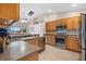 Modern kitchen with stainless steel appliances and wood cabinets at 4264 Wordsworth Way, Venice, FL 34293
