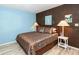 Bedroom with a patterned comforter and light wood floors at 4695 W Price Blvd, North Port, FL 34286