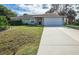 Single-story house with a white garage door and a long driveway at 4695 W Price Blvd, North Port, FL 34286