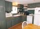 Galley kitchen with green cabinets and white appliances at 476 Boxwood Dr, Venice, FL 34285