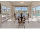 Bright breakfast nook with glass table and French doors leading to a pool and golf course view at 487 Summerfield Way, Venice, FL 34292