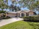 Tan house with a two-car garage and manicured lawn at 487 Summerfield Way, Venice, FL 34292