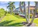 Landscaped backyard with lush grass and palm trees at 49 Perimeter Dr, Englewood, FL 34223