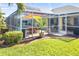 Spacious screened patio with pool, table, and lush landscaping at 49 Perimeter Dr, Englewood, FL 34223