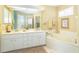 Double vanity bathroom with beige walls and a large bathtub at 49 Perimeter Dr, Englewood, FL 34223