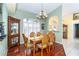 Bright dining room features hardwood floors, chandelier, and wood dining set at 49 Perimeter Dr, Englewood, FL 34223