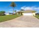 Long driveway leading to a yellow house with a white garage door at 49 Perimeter Dr, Englewood, FL 34223
