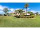 Landscaped yard with a yellow house and palm trees at 49 Perimeter Dr, Englewood, FL 34223