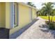 House exterior featuring a yellow painted wall and gravel driveway at 49 Perimeter Dr, Englewood, FL 34223