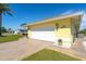 White garage door on a yellow house with a landscaped yard at 49 Perimeter Dr, Englewood, FL 34223