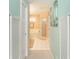 Hallway leading to a bathroom with light blue walls and white doors at 49 Perimeter Dr, Englewood, FL 34223