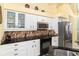Modern kitchen with stainless steel appliances and granite countertops at 49 Perimeter Dr, Englewood, FL 34223