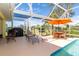 Enclosed pool and patio area with lounge chairs and dining table at 49 Perimeter Dr, Englewood, FL 34223