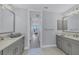 Double vanity bathroom with gray cabinets and a large mirror at 503 N Tamiami Trl # 301, Venice, FL 34285