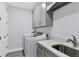 Laundry room with washer, dryer, cabinets, and utility sink at 503 N Tamiami Trl # 301, Venice, FL 34285
