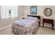 Bedroom with a floral bedspread and a small table at 5031 Bella Terra Dr, Venice, FL 34293