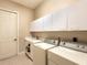 Laundry room with washer, dryer, and cabinets at 5031 Bella Terra Dr, Venice, FL 34293