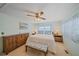 Bright bedroom with a queen-size bed, dresser, and ceiling fan at 521 Roma Road, Venice, FL 34285