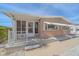 Tan single-wide manufactured home with white trim, covered porch, and landscaped walkway at 521 Roma Road, Venice, FL 34285