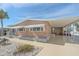 Tan single-wide home with carport, awning, and landscaped yard at 521 Roma Road, Venice, FL 34285