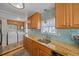 Modern kitchen with granite countertops, wood cabinets, and a blue-tiled backsplash at 521 Roma Road, Venice, FL 34285