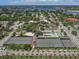 Aerial shot of tennis and basketball courts surrounded by a community, with a park, courts, and palm-lined streets at 525 Manatee Ct # 4, Venice, FL 34285