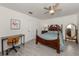 Bedroom featuring a ceiling fan, tile floors, a wooden bed frame, and a small office space at 525 Manatee Ct # 4, Venice, FL 34285