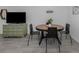 Dining area with a round wood table, modern black chairs, and a green dresser underneath a television at 525 Manatee Ct # 4, Venice, FL 34285