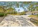 Long driveway leading to a house and garage, surrounded by trees at 610 Woodview Way, Bradenton, FL 34212